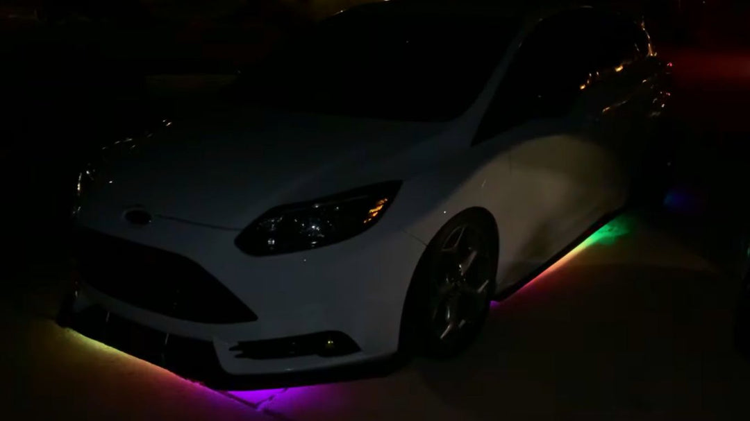 Neon LED Underglow kit on white Ford car..