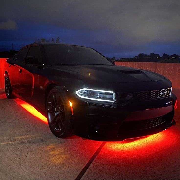 Red Underglow lights on black car.